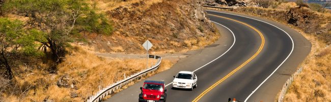 Cars navigate the Pali Highway around the cliffs of West Maui.